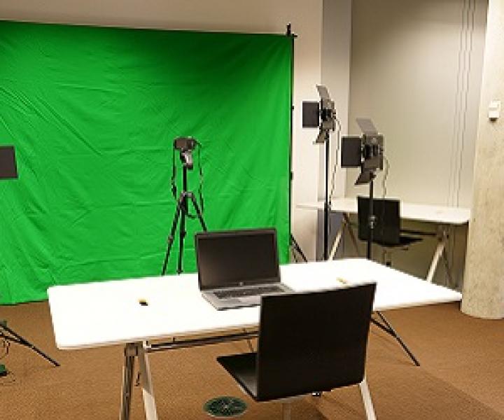 An image of a green screen and camera set up with lights.
