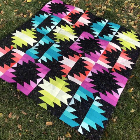 quilt by Toni Corbett with sets of stripes in different hues of the same color going from lightest outside to darkest inside or vice versa, and the stripes set off by shapes or outlines in black