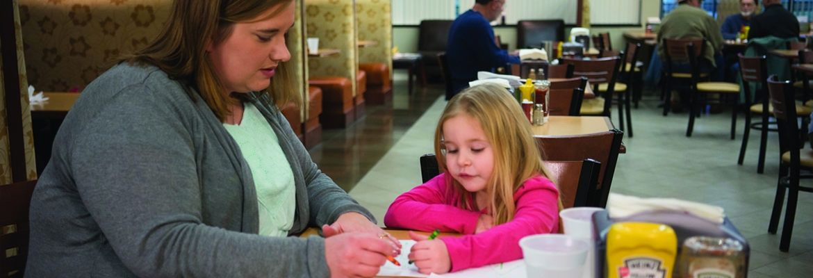 Mother helping daughter write