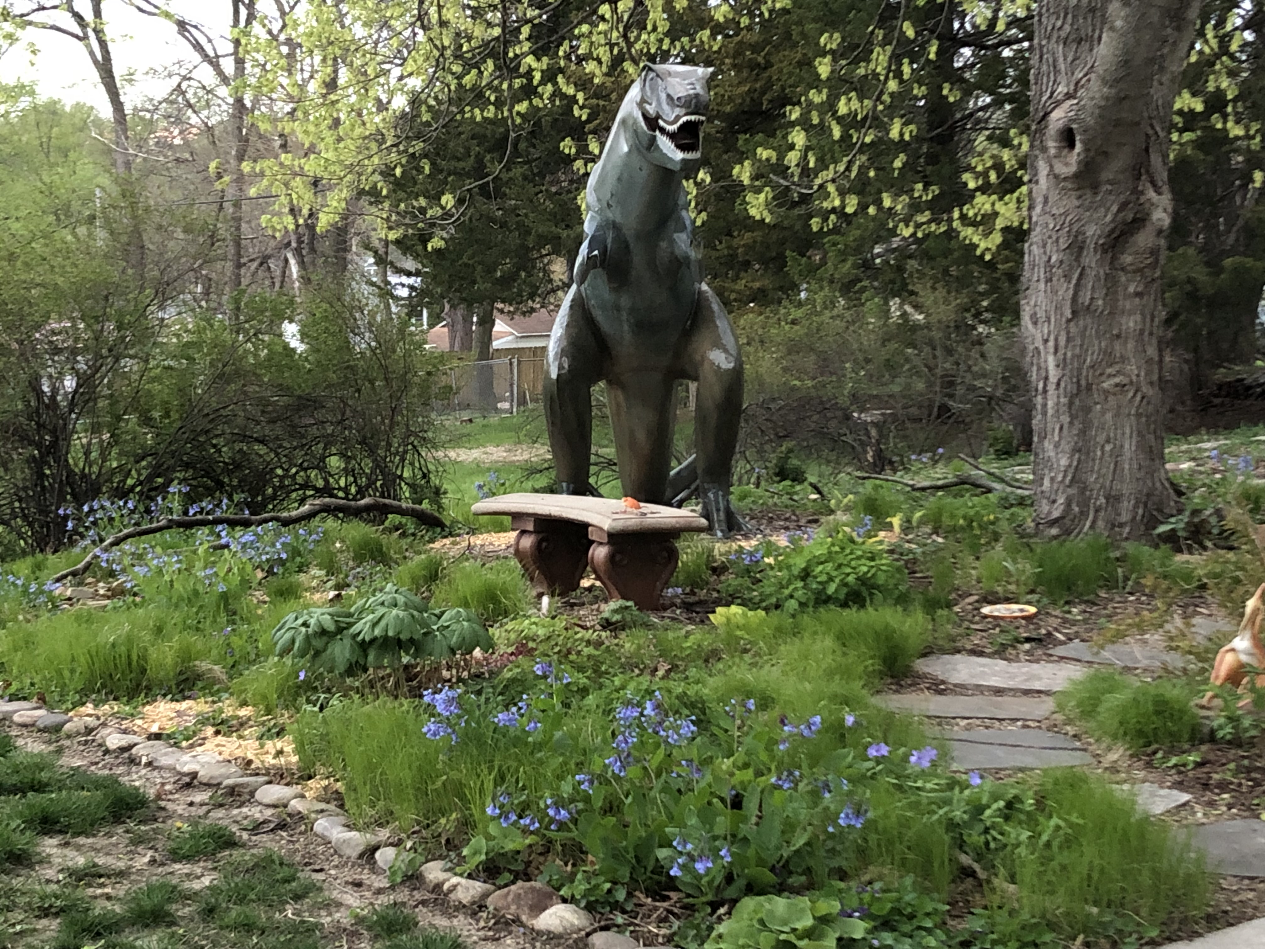 Garden with native plants and a dinosaur sculpture 