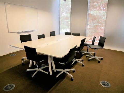 Central Study Room 1 with conference table. chairs, and whiteboard on wall