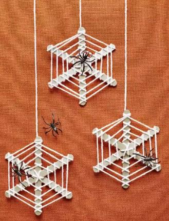 Spider webs made from popsicle sticks and yarn with plastic spiders