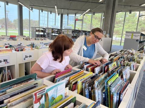 Anna Ramirez browsing the shelves with youth librarian Samantha Reid