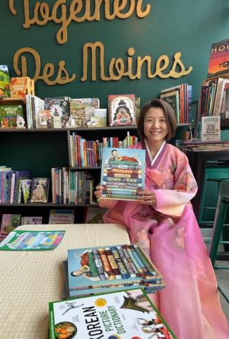 A photo of author Tina Cho holding her book, The Princess and the Grain of Rice.