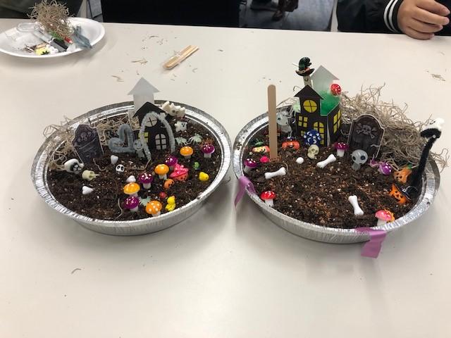 Two scare-rariums decorated with haunted houses, bones, mushrooms, and headstones. 