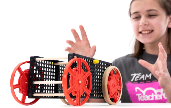 Girl with rubber band racer car. 