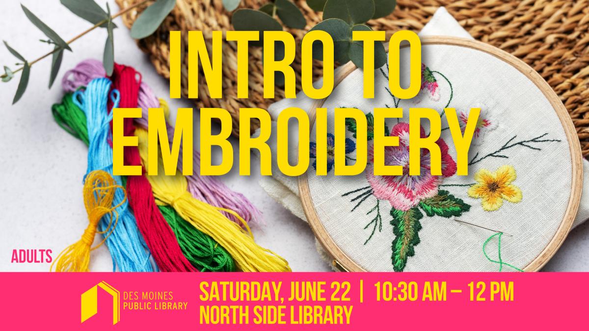 An embroidery hoop displaying embroidered flowers and leaves, with colorful thread beside it