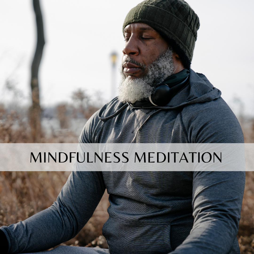 man meditating outside in tall grass